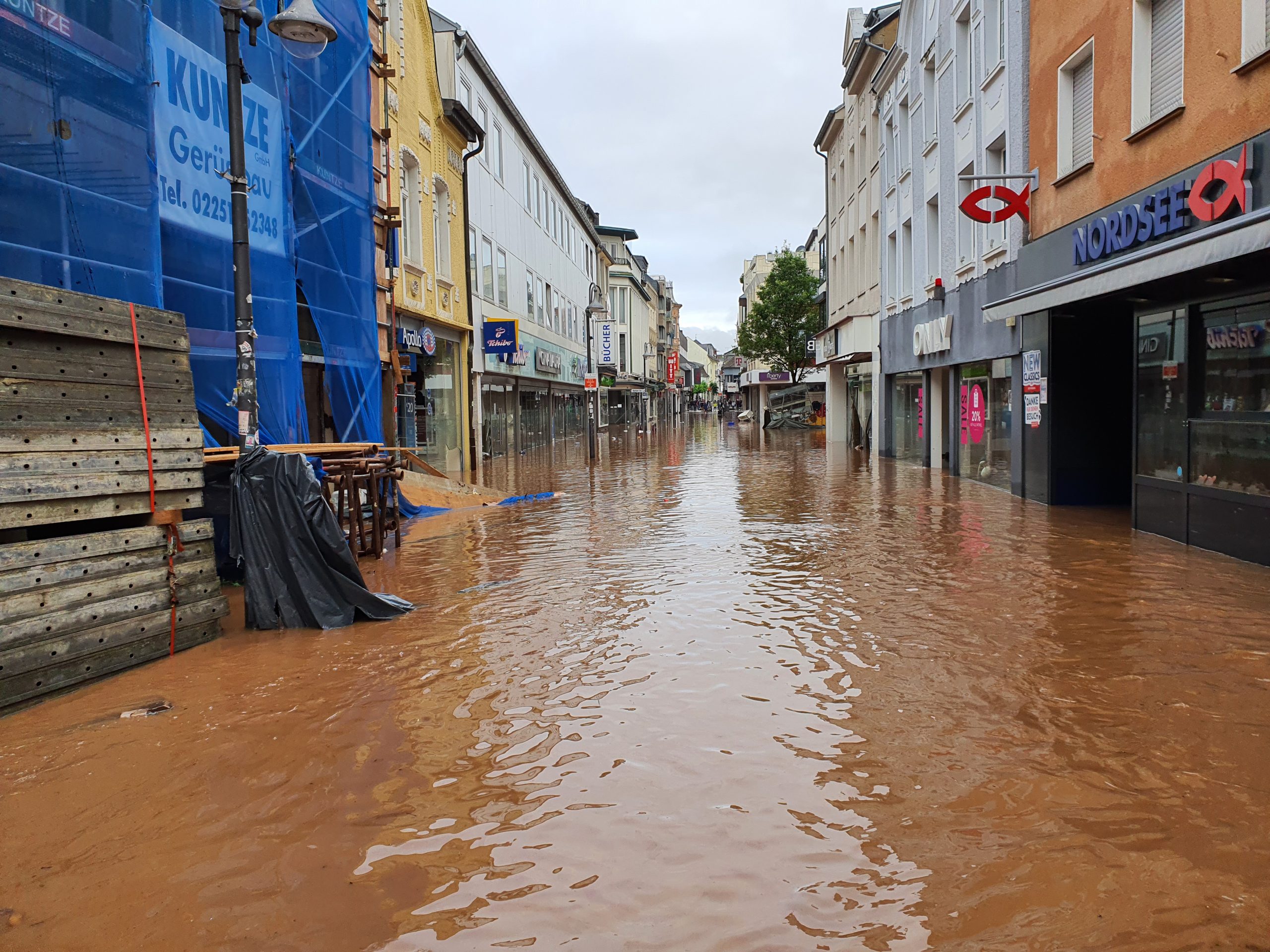 Die Fußgängerzone in der Euskirchener Innenstadt mit braunem Wasser überflutet.