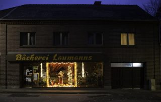 Das Gebäude der Bäckerei Laumanns mit weihnachtlich geschmücktem Schaufenster.